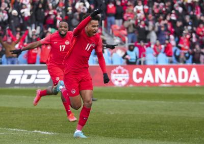 Tajon Buchanan (11), de l’équipe canadienne, fête son but avec Cyle Larin, son coéquipier, après avoir marqué contre la Jamaïque lors de la première période d’un match de qualification pour la Coupe du monde de football masculin à Toronto le 27 mars 2022. (LA PRESSE CANADIENNE/Nathan Denette)