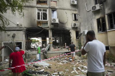 Des Israéliens inspectent un immeuble résidentiel endommagé après que celui-ci a été touché par une roquette tirée depuis la bande de Gaza, à Ashkelon, en Israël, le 9 octobre 2023. (Photo AP / Erik Marmor) Des Israéliens inspectent un immeuble résidentiel endommagé après que celui-ci a été touché par une roquette tirée depuis la bande de Gaza, à Ashkelon, en Israël, le 9 octobre 2023. (Photo AP / Erik Marmor)