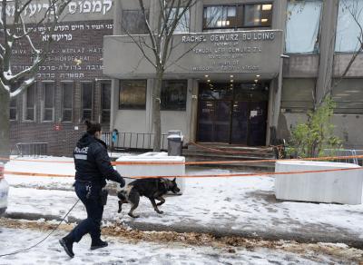 La police de Montréal cherche des indices à l’extérieur de l’école Yeshiva Gedola après que celle-ci a été touchée par des coups de feu. (LA PRESSE CANADIENNE / Ryan Remiorz)